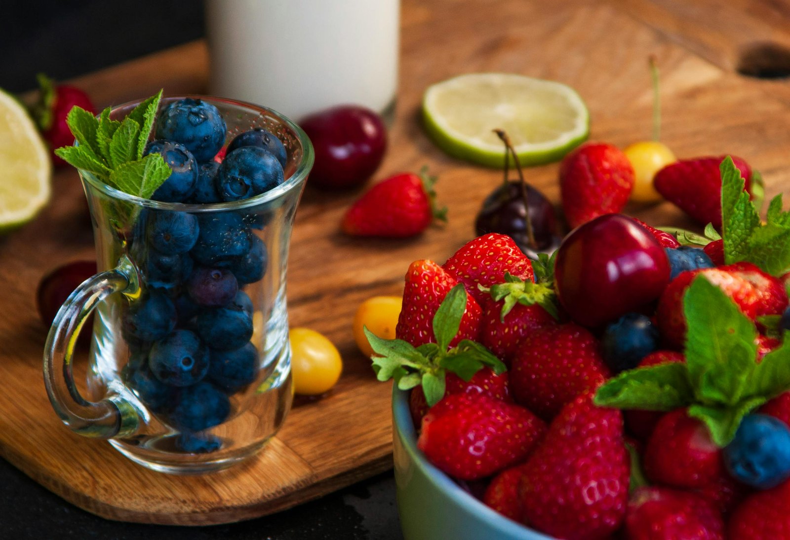 Vibrant display of blueberries, strawberries, and assorted fruits on a wooden board.